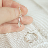 silver hoop earrings in hand for size reference