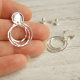 silver stud earring being held for size reference