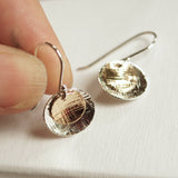 hand holding silver earring for size reference
