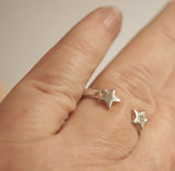 Silver star-shaped earrings on a hand
